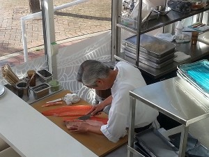 Master Sushi Chef Yoshi Tabo slicing salmon for sushi