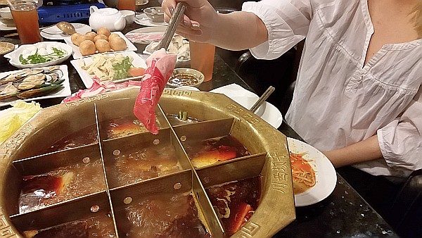 Adding sliced beef to the spicy hotpot