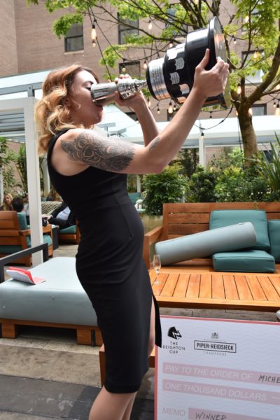 Michelle Medwin takes the traditional drink from the Deighton Cup's Cocktail Jockey trophy - photo by Cathy Browne